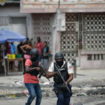 Politimenn jakter etter gjenger i Port-au-Princes nabolag. Foto: AFP