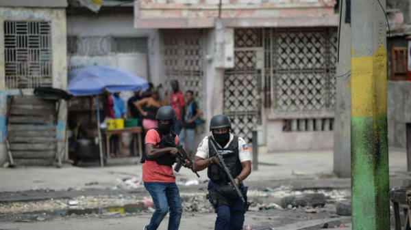 Politimenn jakter etter gjenger i Port-au-Princes nabolag. Foto: AFP